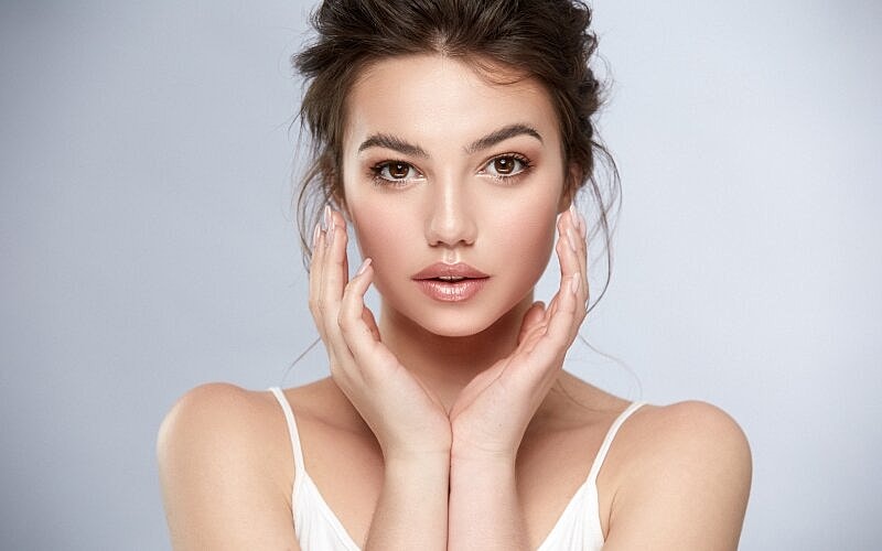 Young woman with natural makeup and soft expression.