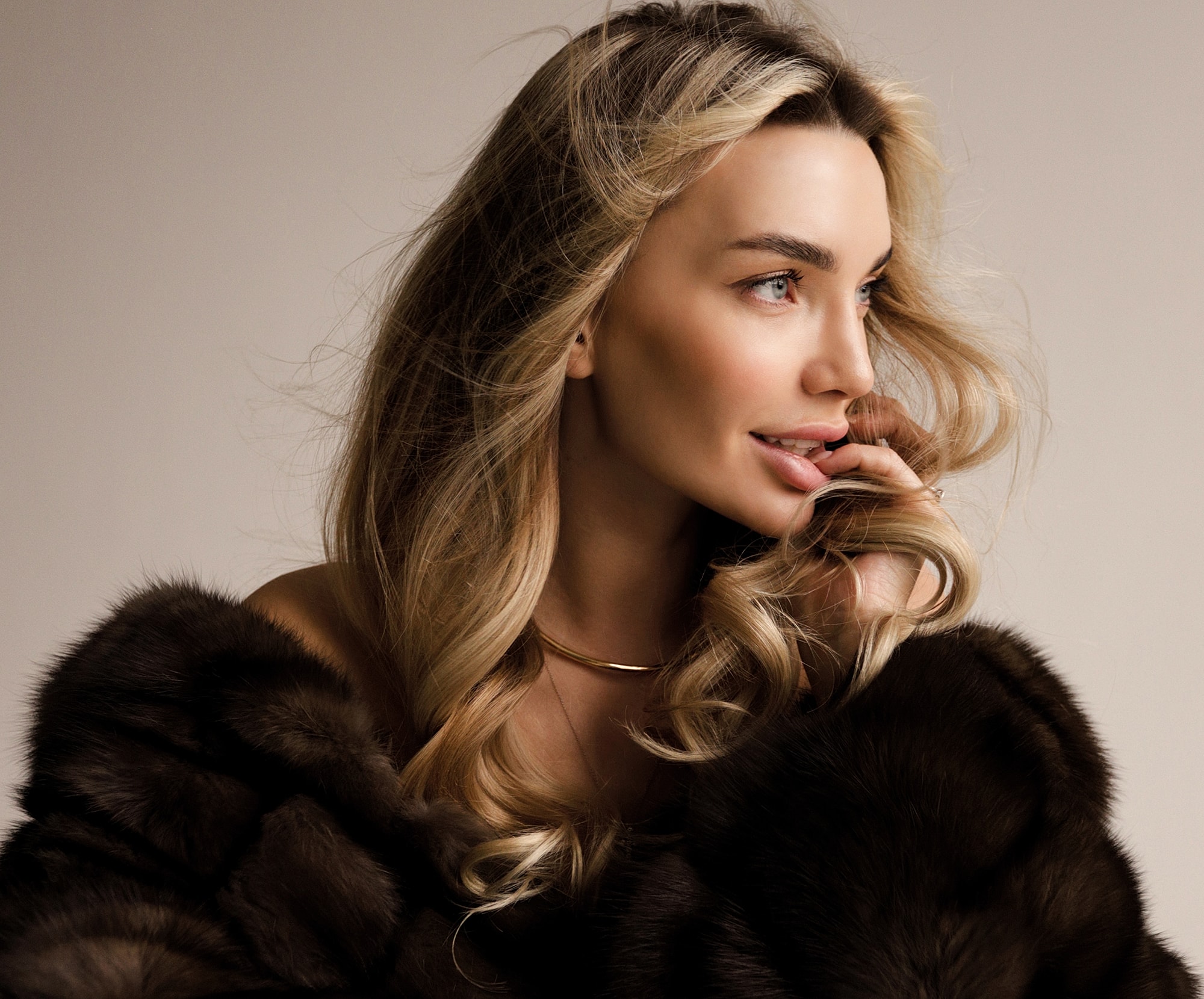 Woman with blonde hair wearing fur coat.